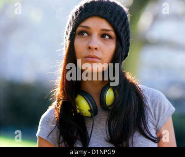 Junge Frau in Wollmütze und tragen Kopfhörer, wegschauen Stockfoto