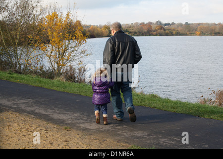 Großvater mit Enkel walking im Freien an einem See im winter Stockfoto