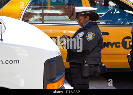 New York City Traffic Warden, Verkehrspolizei, erlässt Parkschein in. Stockfoto
