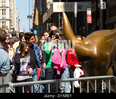 New York City Touristen mit Kamera anzeigen der Wall Street Bull, Bull laden. Stockfoto