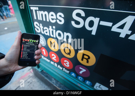 Ein u-Bahn-Fahrer überprüft die neue app der MTA U-Bahn Zeit außerhalb der Times Square Station in New York Stockfoto