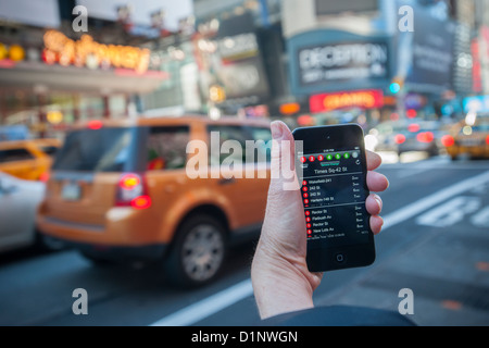 Ein u-Bahn-Fahrer überprüft die neue app der MTA U-Bahn Zeit außerhalb der Times Square Station in New York Stockfoto