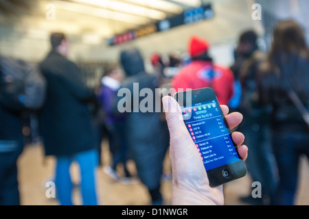 Ein u-Bahn-Fahrer überprüft die neue app der MTA U-Bahn Zeit außerhalb der Times Square Station in New York Stockfoto