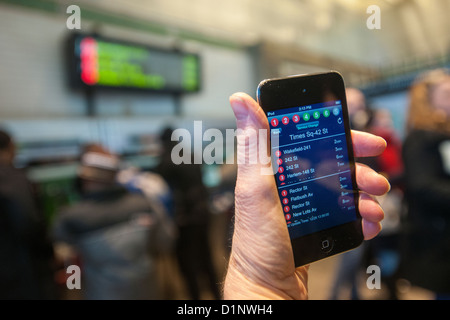 Ein u-Bahn-Fahrer überprüft die neue app der MTA U-Bahn Zeit außerhalb der Times Square Station in New York Stockfoto