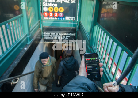 Ein u-Bahn-Fahrer überprüft die neue app der MTA U-Bahn Zeit außerhalb der Times Square Station in New York Stockfoto