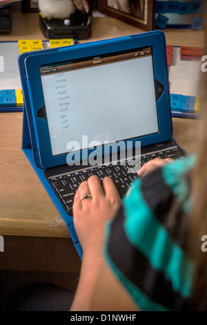 Eine Legasthenie Grundschule Mädchen versucht, diktiert von einem Instruktor Wörter zu buchstabieren. Legastheniker kann Serienbriefe nicht, so dass sie geben. Stockfoto