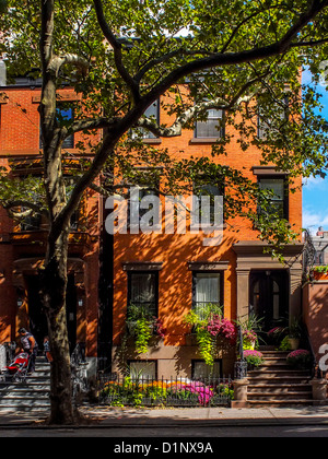 Sonnenlicht scheint auf der Vorderseite ein Reihenhaus aus rotem Backstein auf der State Street in Brooklyn Heights, New York City. Stockfoto