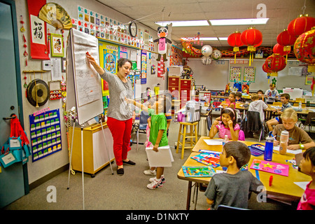 Schüler der ersten Klasse lernen Mandarin-Chinesisch in Laguna Niguel, CA, Grundschule. Beachten Sie die chinesische Schriftzeichen auf a-Frame-Diagramm. Stockfoto