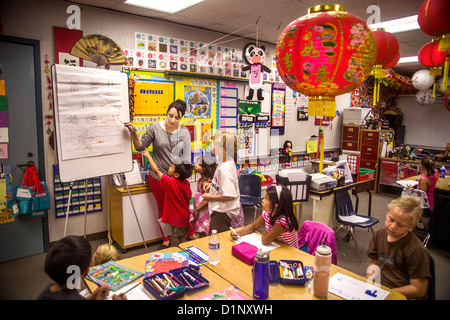 Schüler der ersten Klasse lernen Mandarin-Chinesisch in Laguna Niguel, CA, Grundschule. Beachten Sie die chinesische Schriftzeichen auf a-Frame-Diagramm. Stockfoto