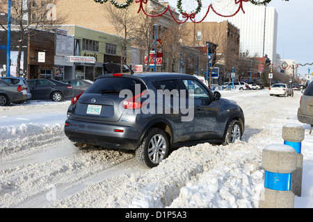 Auto stecken im Tiefschnee auf im Stadtzentrum gelegenes City Straße Saskatoon Saskatchewan, Kanada Stockfoto