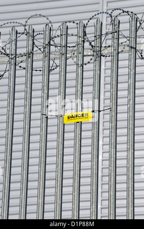 Warnschild Warnung vor Ziehharmonika-Rasiermesserdraht auf verzinktem Stahl montiert wies Zaun. Stockfoto