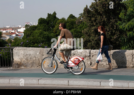 Frau Mädchen zu Fuß junger Mann Reiten Gemeinschaft Leihräder Espana in Sevilla-Sevilla-Spanien-Boris-bikes Stockfoto