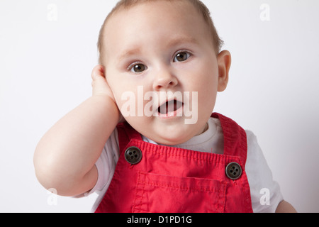 Babymädchen mit Hand am hören Stockfoto