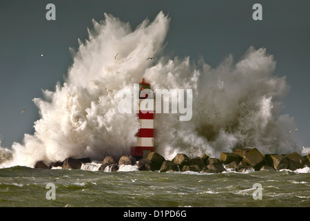 Die Niederlande, IJmuiden, Sturm. Wellen gegen Leuchtturm oder Leuchtfeuer. Stockfoto