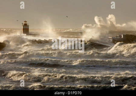 Die Niederlande, IJmuiden, Sturm. Wellen gegen Leuchtturm oder Leuchtfeuer. Stockfoto