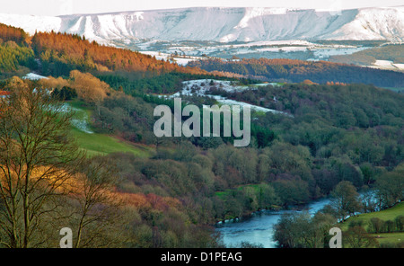 HERBSTLICHE BÄUME UMGEBEN DEN FLUSS WYE IN DER NÄHE VON ERWOOD MIT SCHNEE AUF DEN SCHWARZEN BERGEN Stockfoto