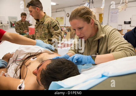 US Navy Lt. j.g. Laura Cook, Recht, Arzthelferin für Provincial Reconstruction Team (PRT) Farah, wertet einen verletzten afghanischen Polizisten an der Verpflegungsstation auf FOB Farah, Dez. 31.  Vier Mitglieder von der afghanischen nationalen Polizei (ANP) beteiligt an einem IED-Streik durch PRT Farah medizinisches Personal behandelt wurden, die 541st nach vorn OP-Team (Airborne) und Koalition zwingen Sanitäter bei FOB Farah-Hilfe-Station.  PRT Farah widmet sich trainieren, beraten und unterstützen afghanische Staats-und Regierungschefs bei den Stadtwerken, Bezirks und Landesebene in der Provinz Farah, Afghanistan.  Ihre zivile Militär-Team ist com Stockfoto