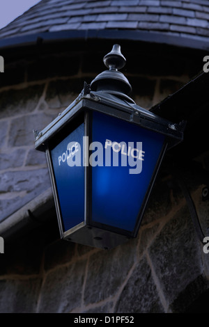 Die blaue Lampe der Polizei leuchtet nachts vor der alten Castletown Polizeistation Stockfoto