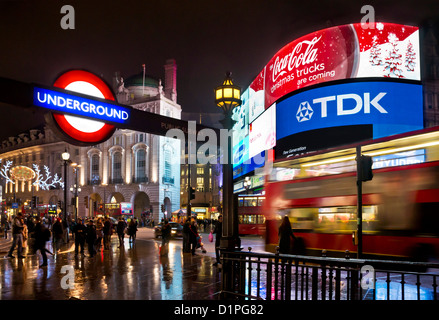 Geschäftige Menschen und ein verschwommener Red London-Bus in einer Geschäftigen Nacht in der Nähe der Piccadilly Circus U-Bahn-Station Sign Central London England GB UK Europe Stockfoto