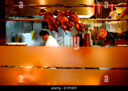 Mann in einem chinesischen Restaurant mit Enten Spieß Rösten im Fenster, Paris, Frankreich Stockfoto