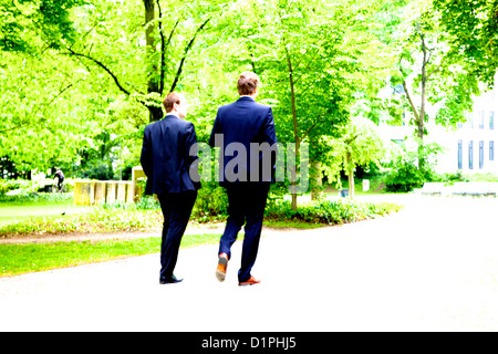 zwei Geschäftsleute in blauen Anzügen Spaziergang durch einen Park in Hamburg, Deutschland Stockfoto