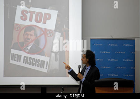 Maikel Nabil Sanad, ein ägyptischer Blogger und politischer Aktivist, zeigt auf ein Bild, das während einer Rede an der Universität Tel Aviv am 02. Januar 2012 gezeigt wurde, in dem der ägyptische Premierminister Mohamed Mursi mit dem Schriftzug „Stop, New Fascism“ abgebildet ist. Maikel wurde 2010 berühmt, weil er sich weigerte, in der ägyptischen Armee zu dienen, dann 2011 für seine Rolle in der ägyptischen Revolution. Er ist bekannt dafür, dass er liberal-demokratische Werte in Ägypten fördert und sich für friedliche Beziehungen zwischen Ägypten und Israel einsetzt. Stockfoto