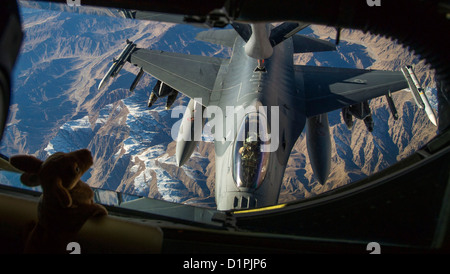 Ein 340. Expeditionary Luft Refueling Squadron KC-135 Stratotanker tankt eine f-16 Fighting Falcon über Afghanistan, Dez. 22. Captain Matthew Mills, 340. Expeditionary Air Refueling Squadron Pilot hält ein Stofftier an Bord für seine Nichte ihr ev zeigen Stockfoto