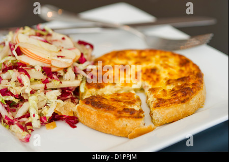 Eine individuelle Quiche Lorraine serviert mit Krautsalat. Stockfoto