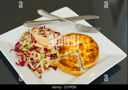 Eine individuelle Quiche Lorraine serviert mit Krautsalat. Stockfoto