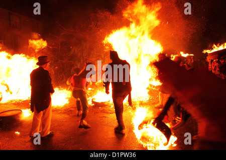 Männer in Kostümen Licht am Lagerfeuer bei der New Year Eve Tar Bar'l (Tar Barrel) Feierlichkeiten in Allendale, Northumberland. Stockfoto