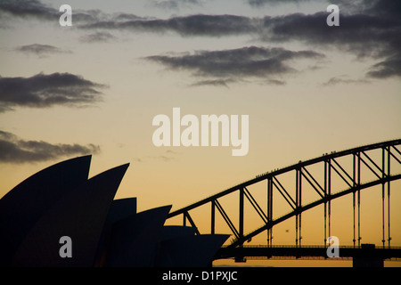 Silhouette des Opernhauses von Sydney und der Harbour Bridge vor einem Sonnenuntergang Stockfoto