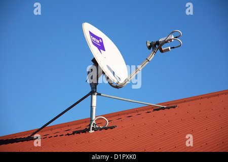 IpStar Satelliten-Internet Breitband Gericht auf einem roten Wellblech-Dach Stockfoto