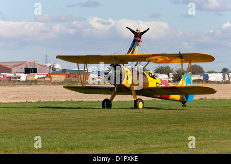 Boeing Stearman A75L-300 Kaydet G-CGPY mit Rollen auf der Piste nach der Landung mit Flügel-Walker winken Stockfoto