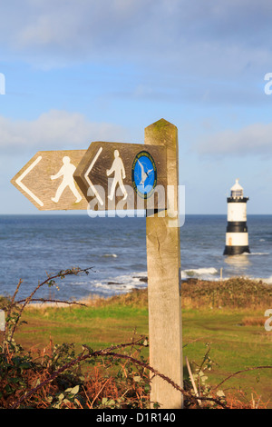 Isle of Anglesey Küstenweg und Wales Coast Path Wegweiser mit Trwyn Penmon Leuchtturm (Du) aus Küste darüber hinaus. Penmon Point North Wales UK Stockfoto