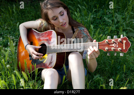 junge Frau Palying Gitarre Stockfoto