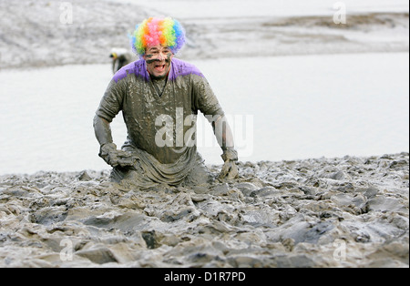 Konkurrenz-Kampf durch den dicken Dreck während der jährlichen Maldon Mud Race in Maldon in Essex. Stockfoto