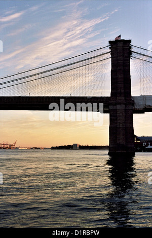 Silhouette von New York Citys Brooklyn Bridge kontrastiert gegen die Rötung Horizont am Abend. Stockfoto