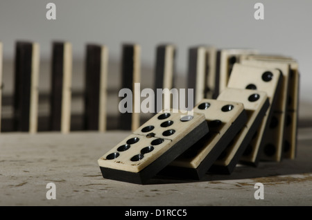 Reihen von aufgereiht altes Elfenbein und Ebenholz Bronze angehefteten stehende Domino blockiert Stücke auf weißem Tan Travertin-Marmor Stockfoto