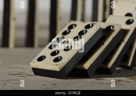 Reihen von aufgereiht altes Elfenbein und Ebenholz Bronze angehefteten stehende Domino blockiert Stücke auf weißem Tan Travertin-Marmor Stockfoto