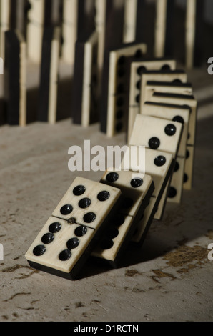 Reihen von aufgereiht altes Elfenbein und Ebenholz Bronze angehefteten stehende Domino blockiert Stücke auf weißem Tan Travertin-Marmor Stockfoto