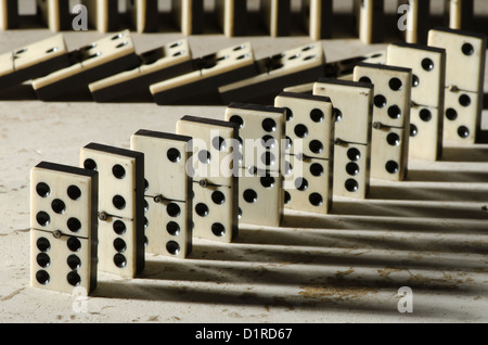 Reihen von aufgereiht altes Elfenbein und Ebenholz Bronze angehefteten stehende Domino blockiert Stücke auf weißem Tan Travertin-Marmor Stockfoto