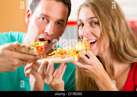 Mann und Frau eine Pizza essen und den Abend genießen Stockfoto