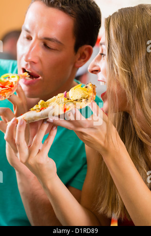 Mann und Frau eine Pizza essen und den Abend genießen Stockfoto