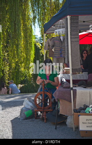 Spinnen von Wolle eine Frau an ihrem Stand in Riccarton outdoor craft Market, Christchurch, Canterbury, Südinsel, Neuseeland. Stockfoto