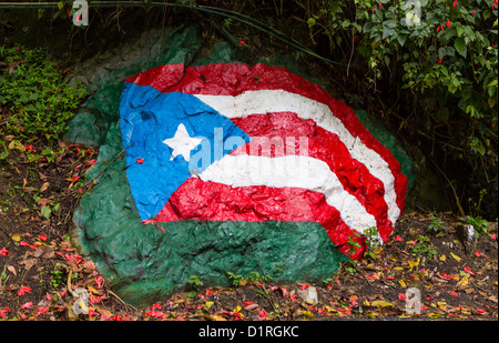 ADJUNTAS, PUERTO RICO - Puerto Rico-Flagge gemalt auf Felsen am Straßenrand. Stockfoto