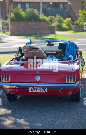 1966 Modell roter ford Mustang mit Surfbrett auf dem Beifahrersitz, newport Beach, sydney, australien Stockfoto