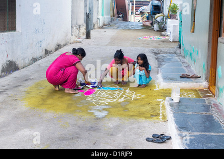 Indische Mutter und Töchter einen Rangoli festival Design außerhalb ihres Hauses während des Festivals von sankranthi. Puttaparthi, Andhra Pradesh, Indien Stockfoto