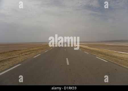 Der Damm und die Straße über den Salzsee Chott El Jerid von Tozeur, Tebili in der Sahara Wüste in Tunesien Stockfoto