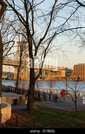 Menschen in East River Park in der Nähe von der Williamsburg Bridge.  East River im Bereich East Village von Manhattan in New York City. Stockfoto