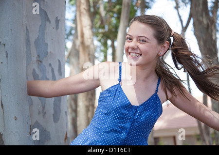 ein junges Mädchen spielt verstecken und suchen im Wald Stockfoto